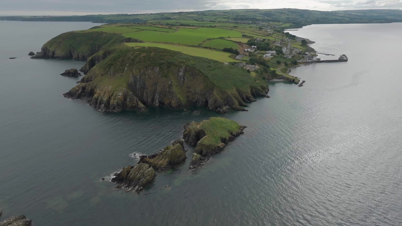 Inquadratura aerea dall'alto di Helvick Head vicino a Dungarvan, che mostra scogliere frastagliate, pascoli verdi e la costa atlantica. Ideale per documentari di viaggio e temi di sostenibilità