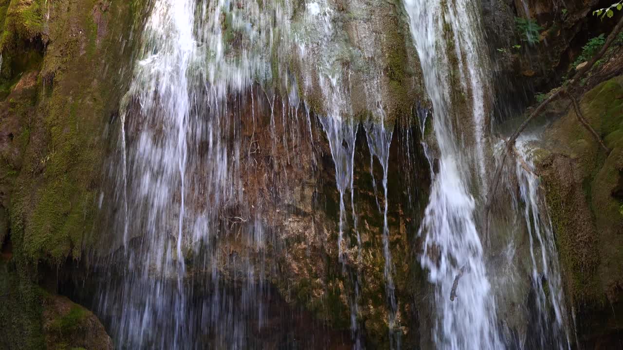 el agua cae desde el acantilado sobre tierra rocosa.
