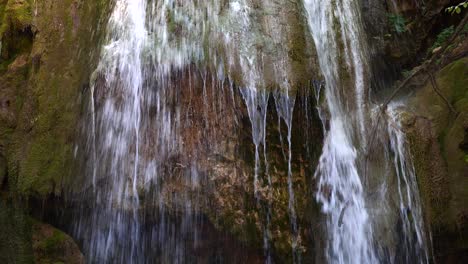 Water-falls-down-from-the-cliff-on-rocky-land