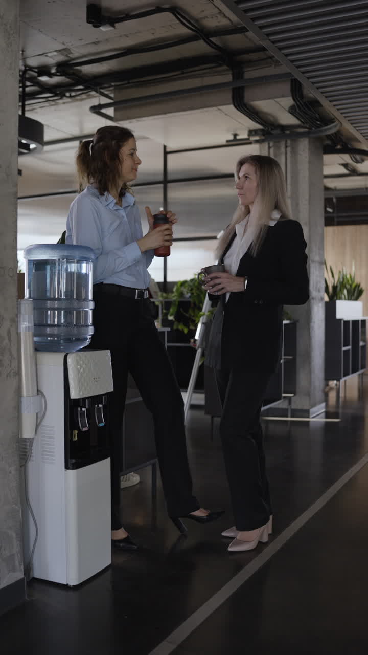 Businesswomen Having a Conversation at the Office Water Cooler