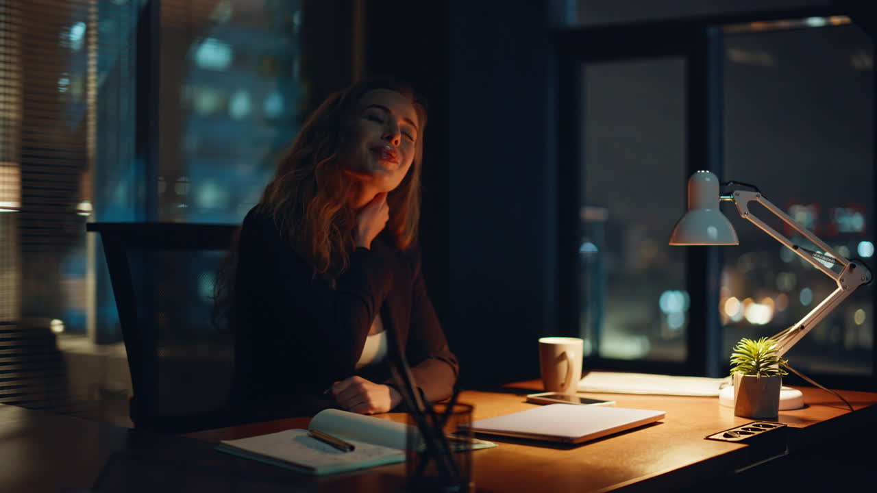 Lavoratore stanco che soffre di mal di testa in ufficio la sera, primo piano. Manager sottoposto a superlavoro