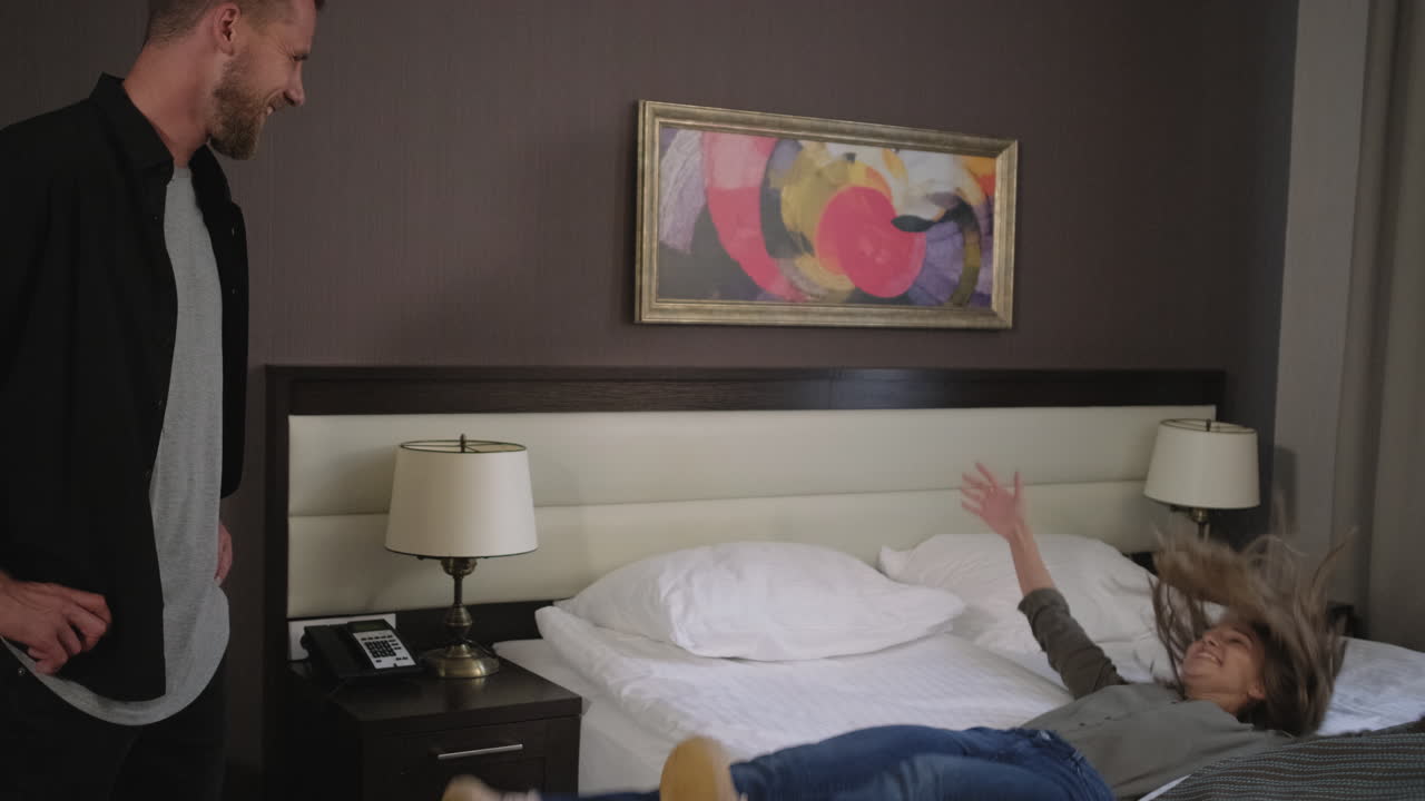 una pareja jugando en una habitación de hotel.