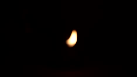 multiple candle flames flickering in darkness