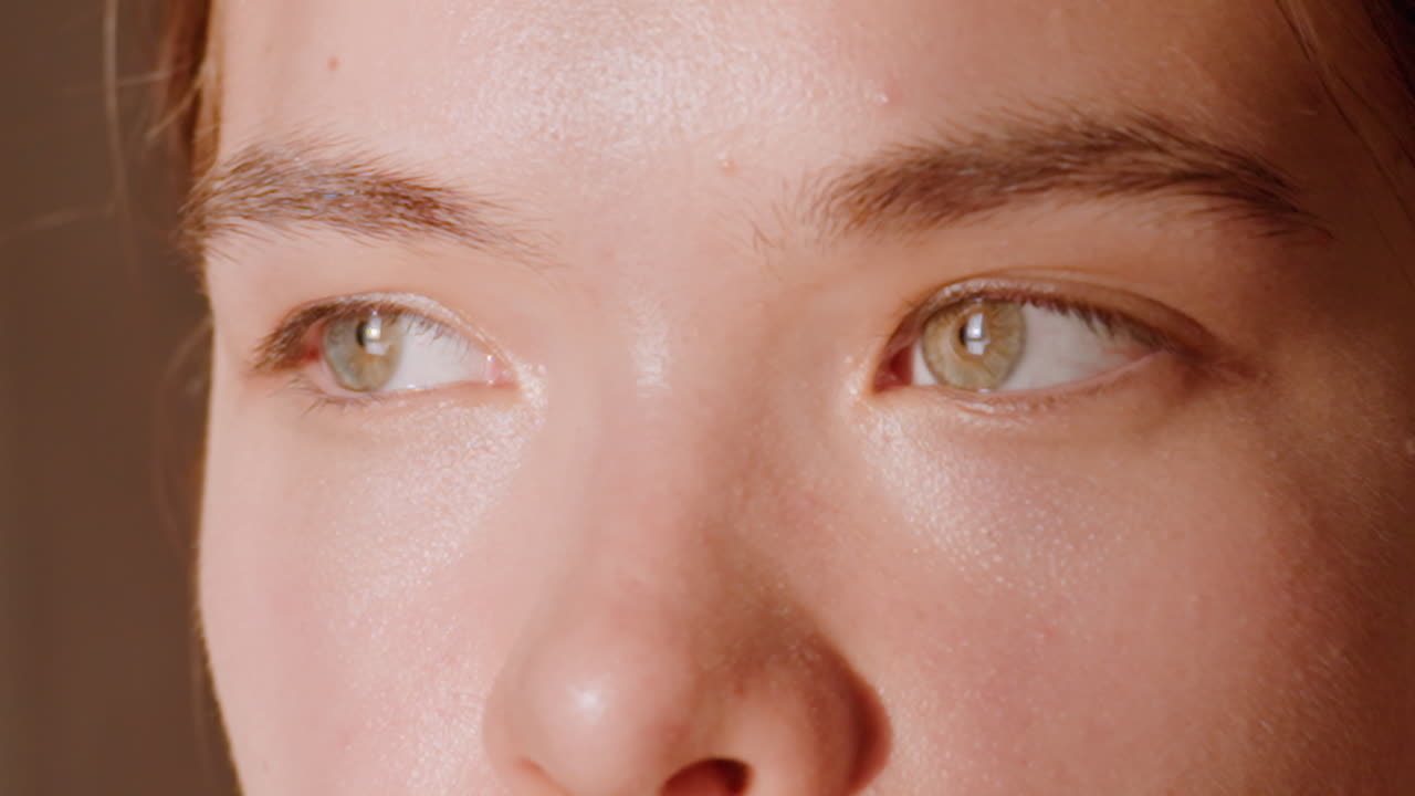 Tight Closeup Caucasian Woman Contemplative Gaze Looking Sideways With Hazel Eyes And Soft Shadows, Subtle Squint And Introspective Mood Suitable For Narrative, Editorial And Mental Health Visuals