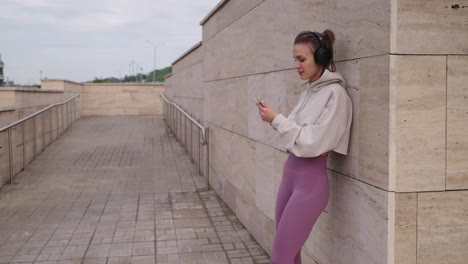 woman using phone while listening to music outdoors