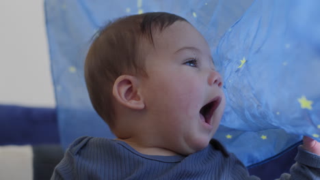 Baby-Lächelt-Und-Lacht-Und-Spielt-In-Zeitlupe-Mit-Einer-Blauen-Seide-Mit-Gelben-Sternen