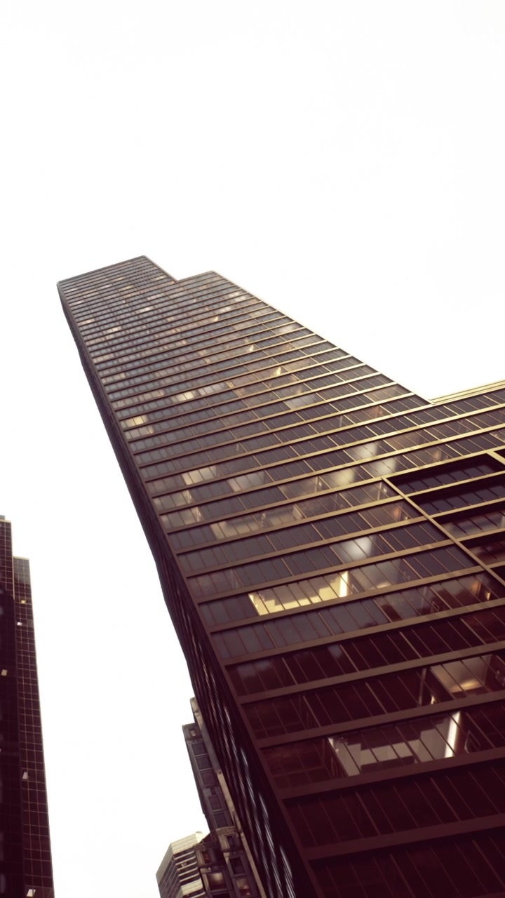 Vista de um edifício alto que se estende até o céu em uma cidade durante o dia.