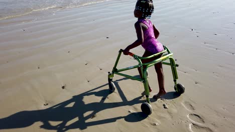 little girl with cerebral palsy playing on the beach