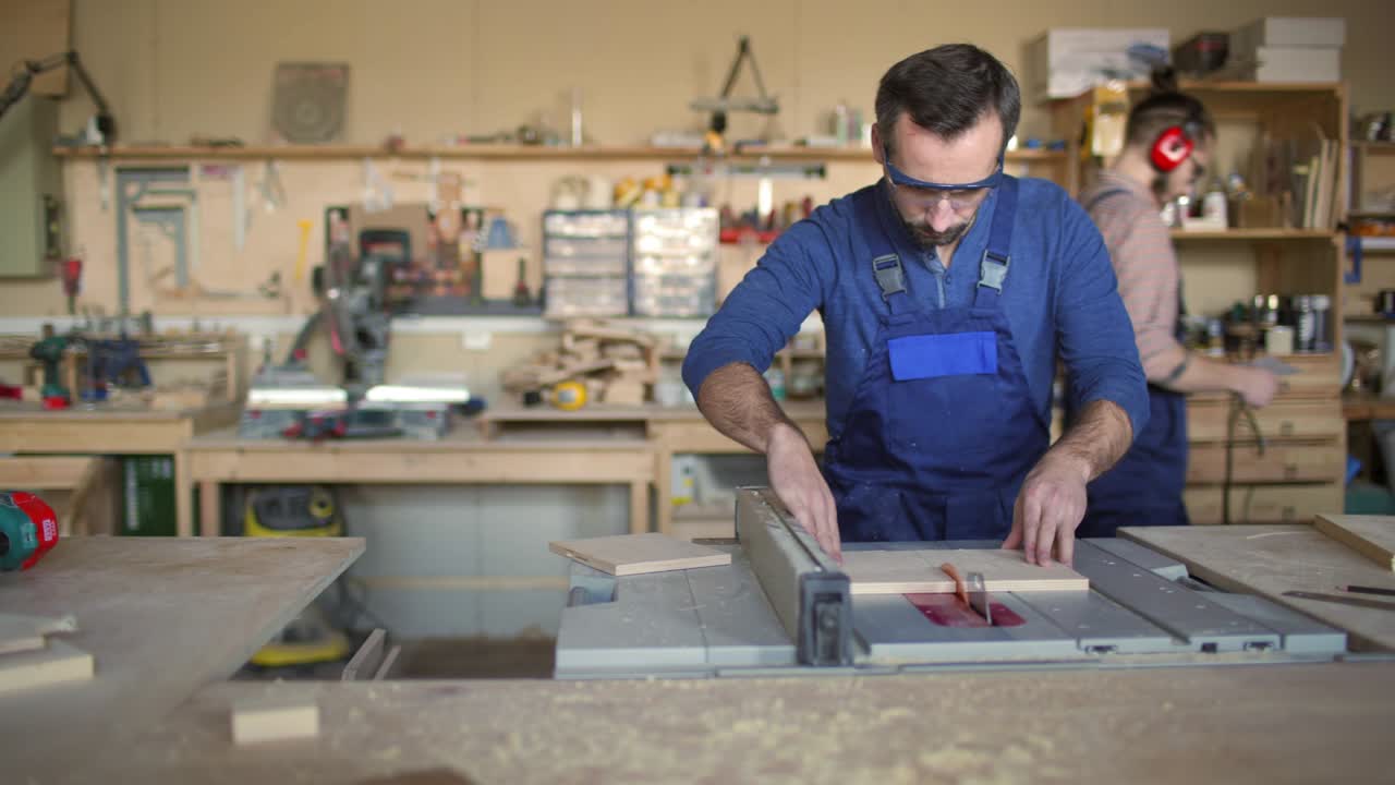 Carpenter Using Saw to Cut Wooden Boards