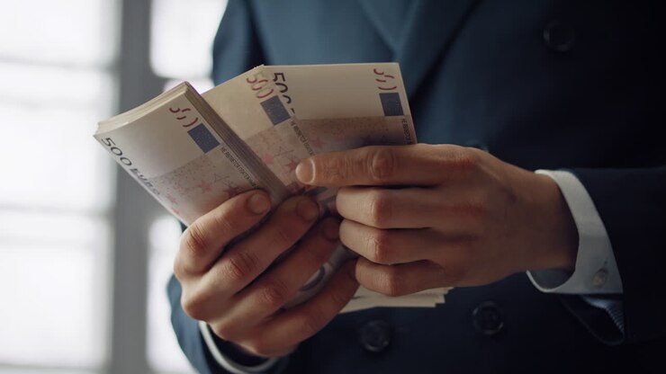 Mains d'homme comptant des billets de banque en gros plan à l'intérieur. Homme d'affaires calculant une liasse de billets