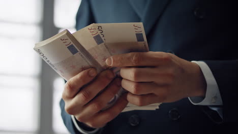 man hands counting banknotes indoors closeup. businessman calculating pack bills