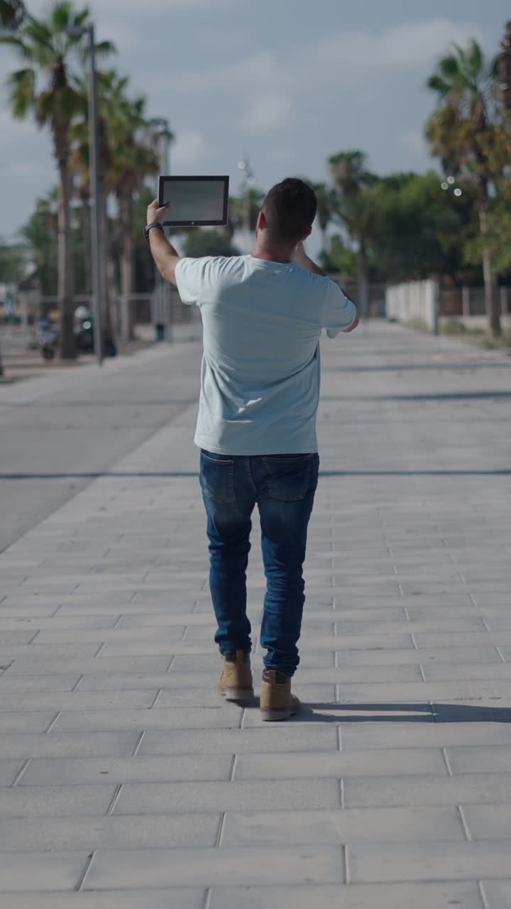 Man walking on street with tablet