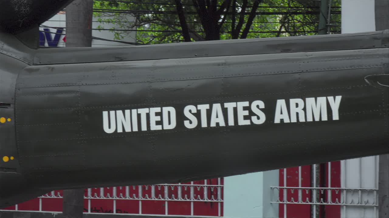 a close-up shot of the side of a military helicopter or aircraft. The white text "UNITED STATES ARMY" stenciled clearly on the dark, olive-green metal fuselage
