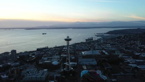 aerial of space needle silhouette as the sun sets over the puget sound
