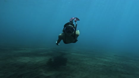 a woman dives in the clear waters of indonesia, exploring the underwater world