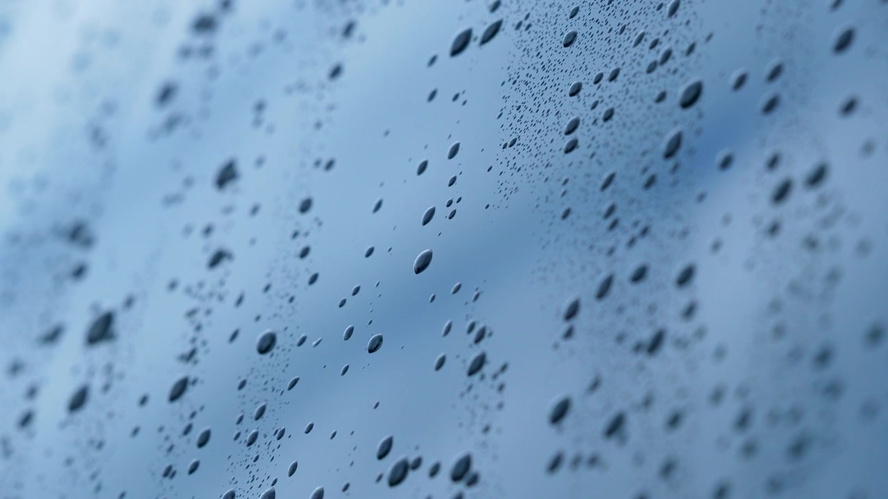 Close up macro shot of water droplets on a window pane during a rainstorm. Authentic texture for wellness, sustainability, and minimalist nature concepts.