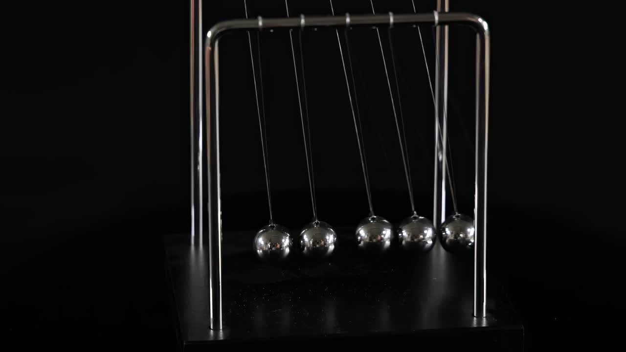 A detailed view of Newton's Cradle demonstrating the motion of metal spheres.