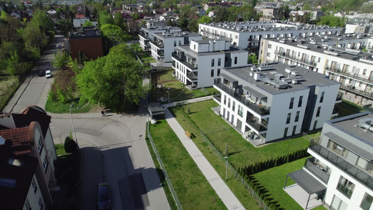 Yeşil bir yerleşim bölgesinde yer alan modern apartman binalarının havadan görünümü