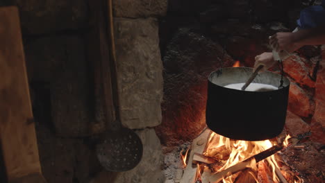 Cheese-Making-Process,-Hand-Stirs-Pot-Heated-by-Fire,-Chobareti,-Georgia,-Pan