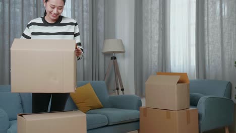 mujer moviendo cajas en su sala de estar