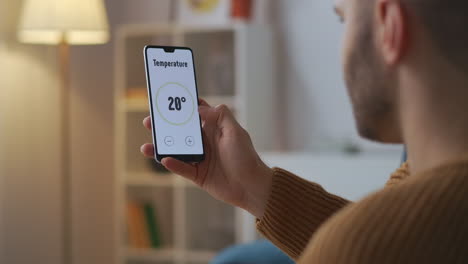 man-is-controlling-and-adjusting-smart-home-system-by-app-in-smartphone-closeup-view-of-gadget-in-male-hands-modern-technology-for-comfort