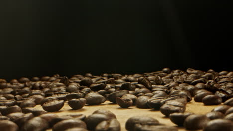 un montón de granos de café arrojados sobre una superficie de madera