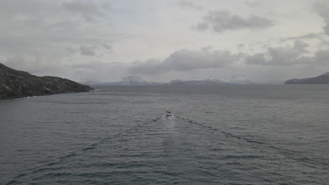 Commercial-fishing-boat-heading-out-to-open-ocean,-drone-follow-cam