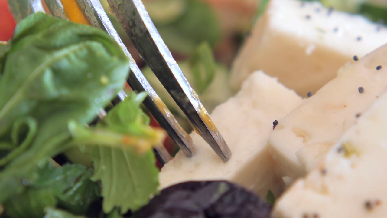 Close-up of Fork Picking Up Cheese from a Fresh Salad