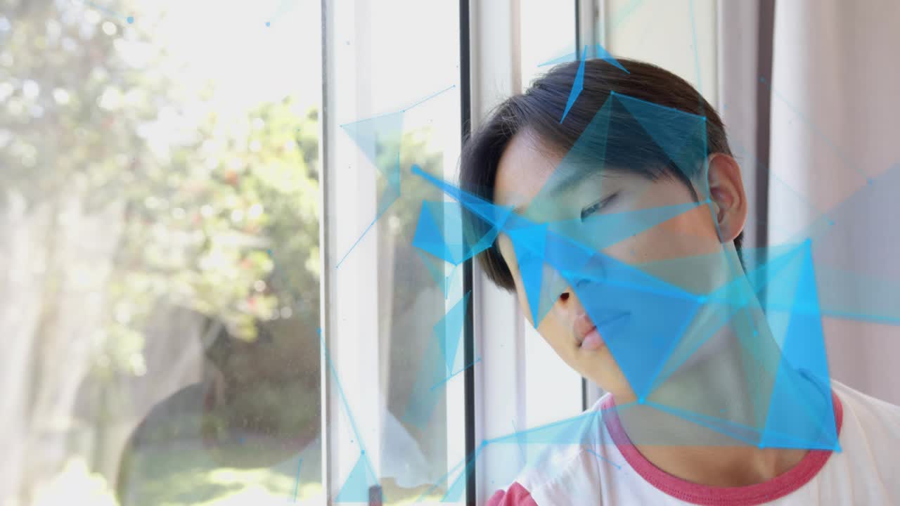 Teenage boy following blue polygon graphics sweeping across window, shifting head for motion design