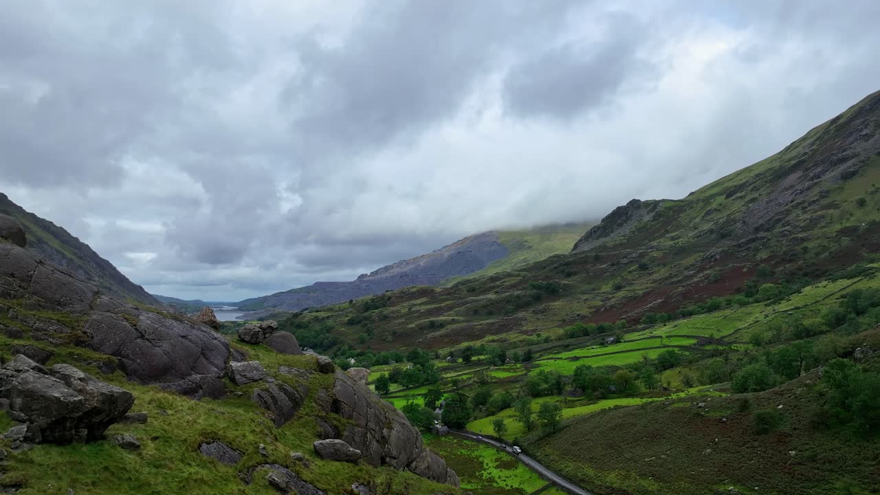 헬리터가 그림 같은 계곡을 가로지르는 시골 도로 위를 날아갑니다.