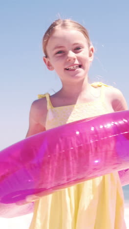 little girl playing with her buoy on the beach