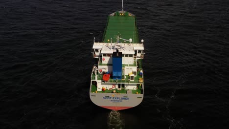 drone overview pullsback to reveal stern of ferry barge as it heads into harbor