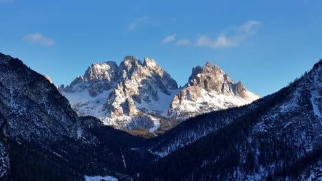 3x zoom of rock formation in the italian dolomites covered in snow during a sunny day (drone footage)