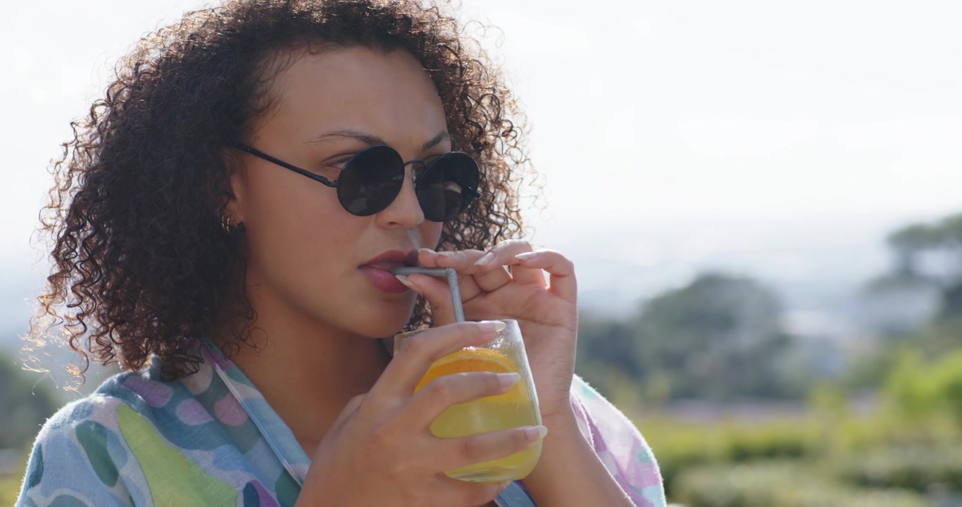 Adult woman in kimono holding lemon drink straw patio camera panning putting shades for sun sipping