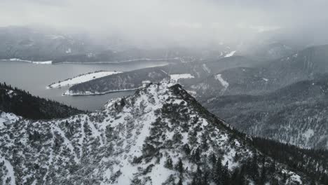 Disparo-Aéreo-Sobre-La-Cima-De-La-Montaña-En-Invierno-Con-Excursionistas-En-La-Cima-En-Un-Frío-Día-Gris