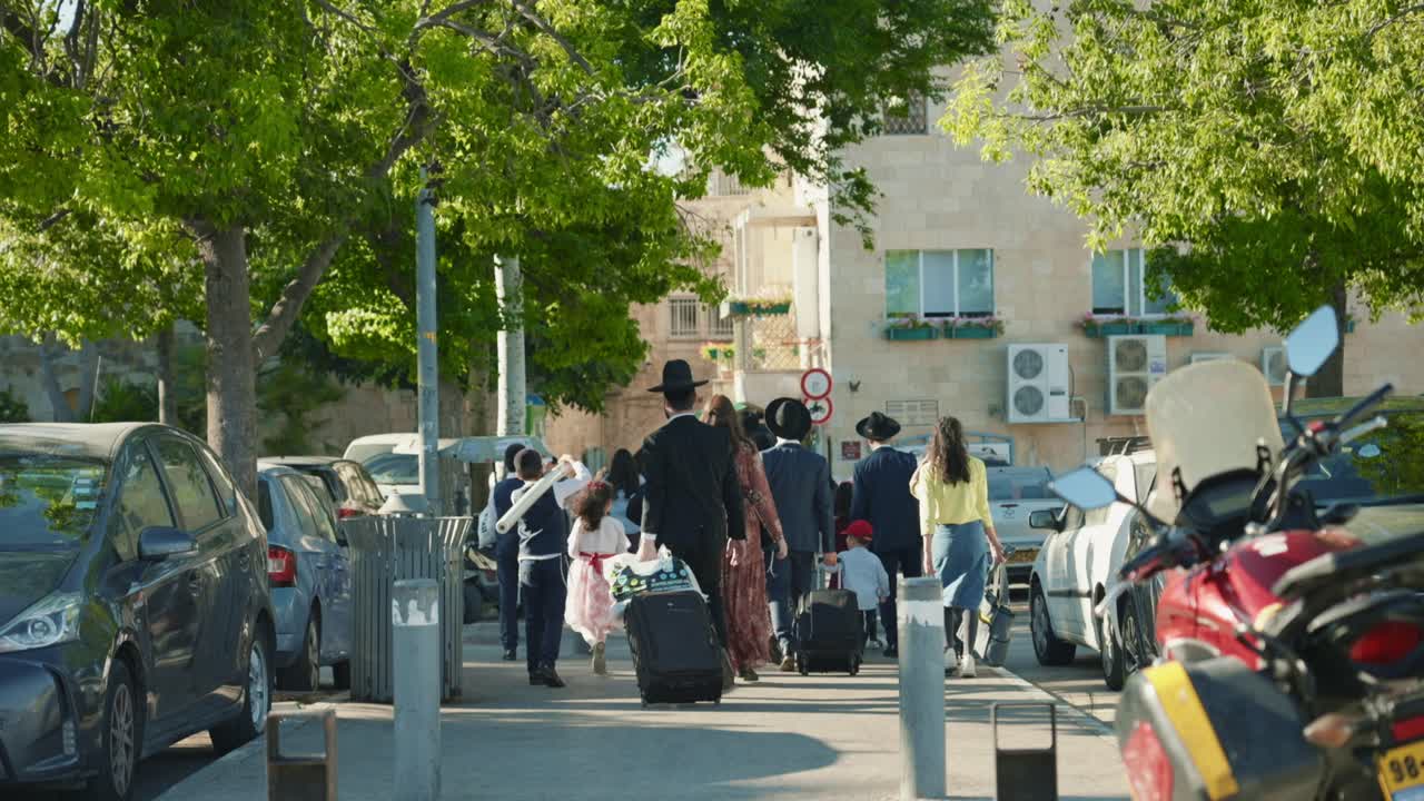 Religious Orthodox Jews walk into old city of Jerusalem to celebrate Shabbat with family in ancient western wall