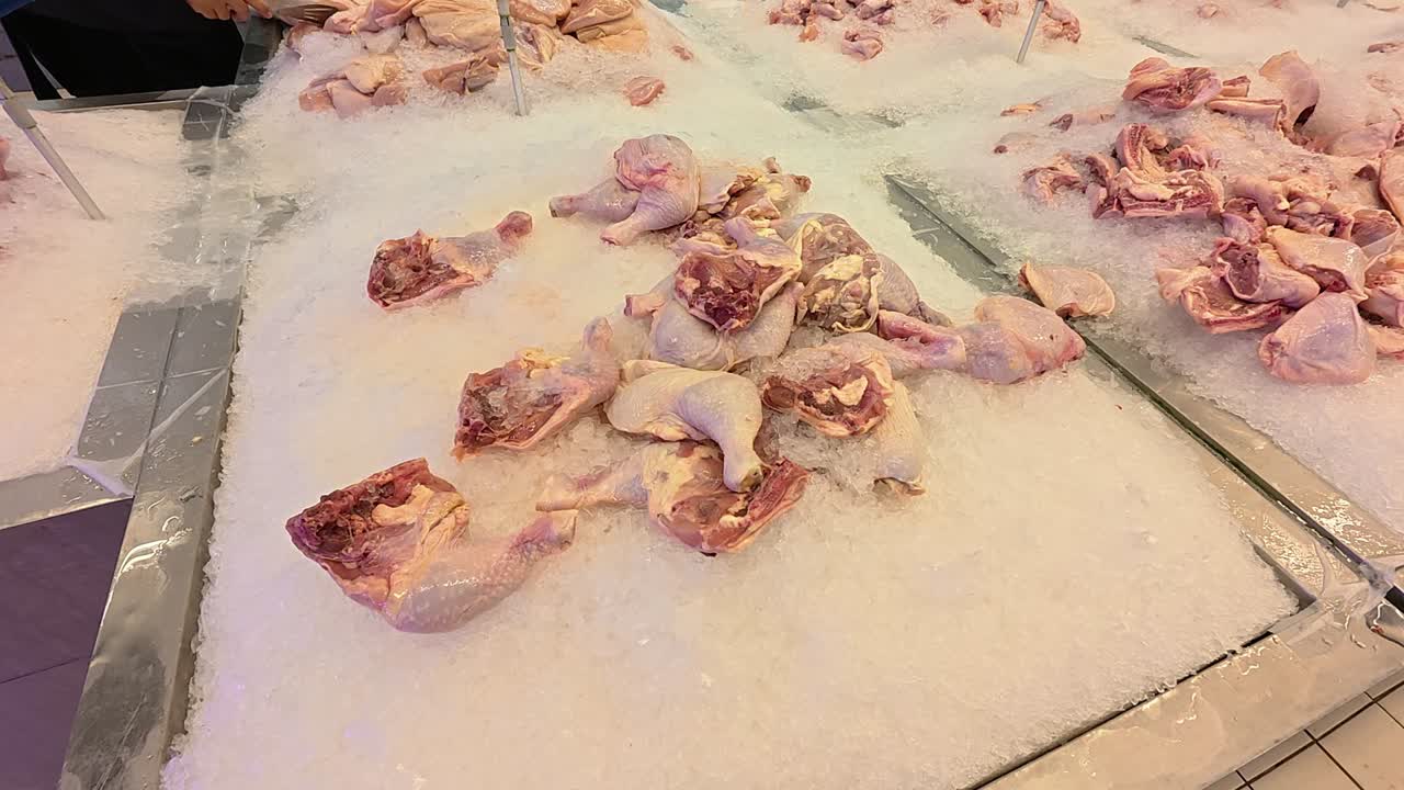 Cut chicken portions are separated and placed on ice for sale. These parts are displayed in the wet market section of a supermarket. Prices are determined by the weight and type of chicken piece