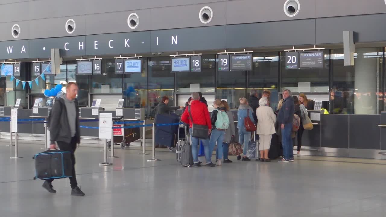 Interior of new modern terminal at Lech Walesa Airport in Gdansk. People waiting in at the check in counter