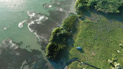 rotating over vegetated and tranquil green lake during sunrise