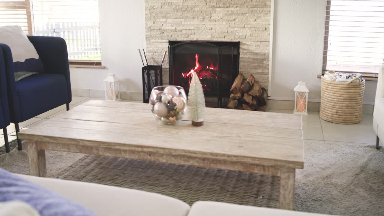 Upon recording start, camera is panning left across coffee table to reveal navy chair, white couch
