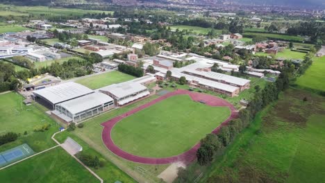 aerial drone shot of sports stadium with athletics running track