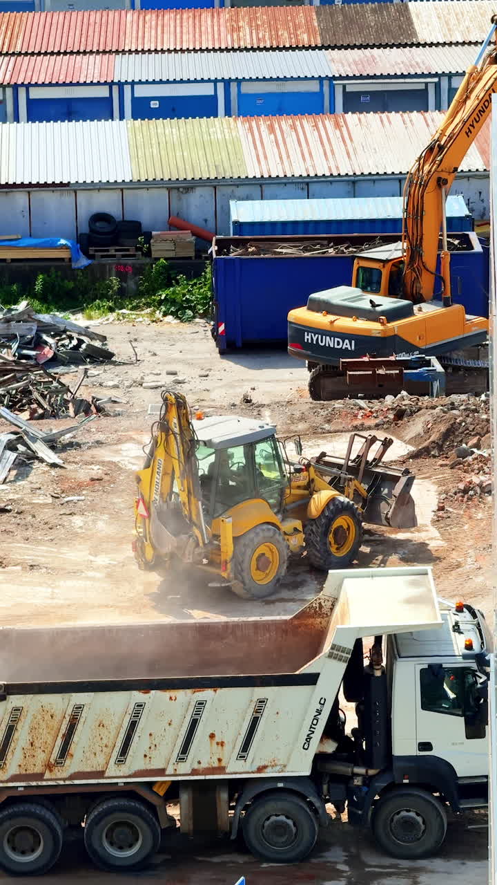 Heavy machinery at site. Excavators and dump trucks move debris at a construction site during the day, showcasing active machinery in use