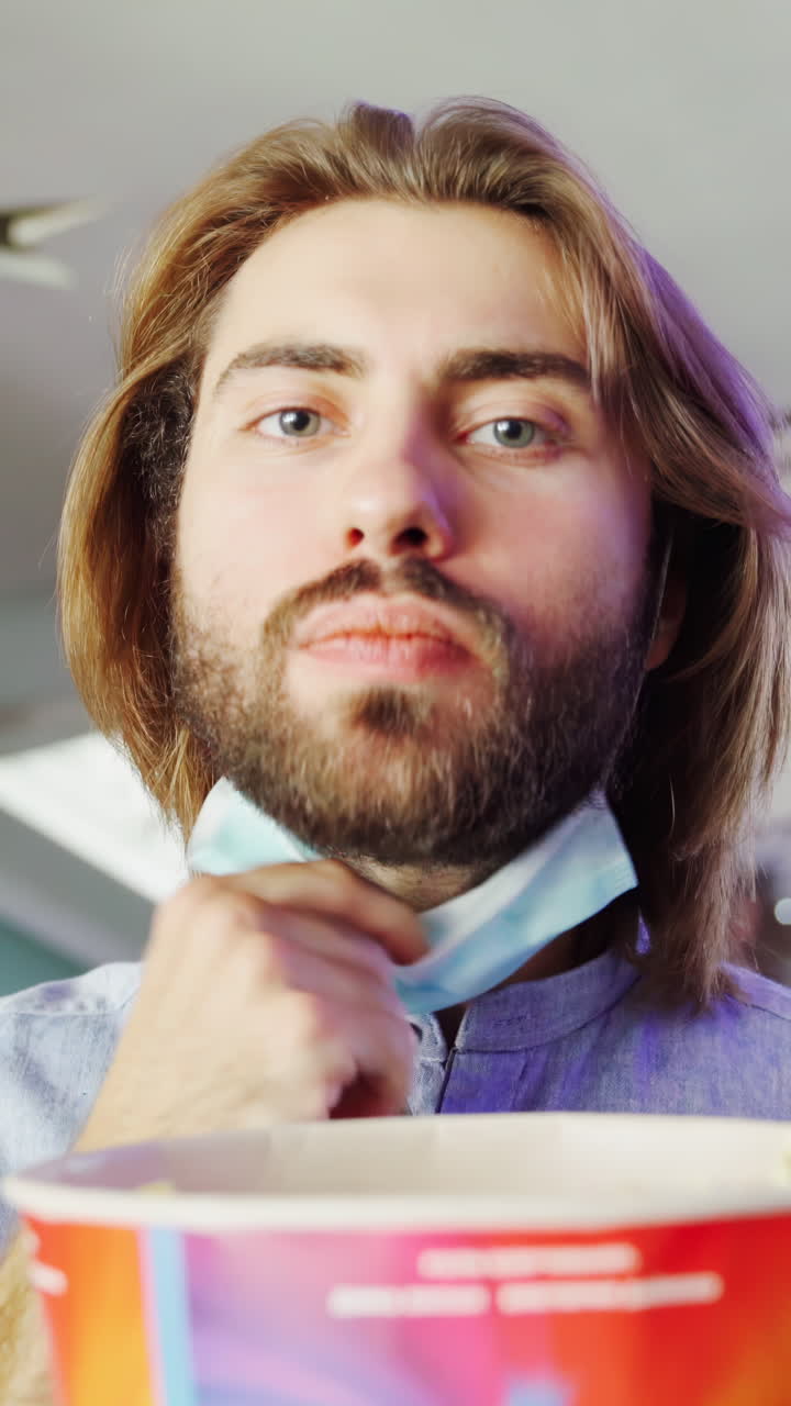 Uomo che guarda un film indossando una maschera