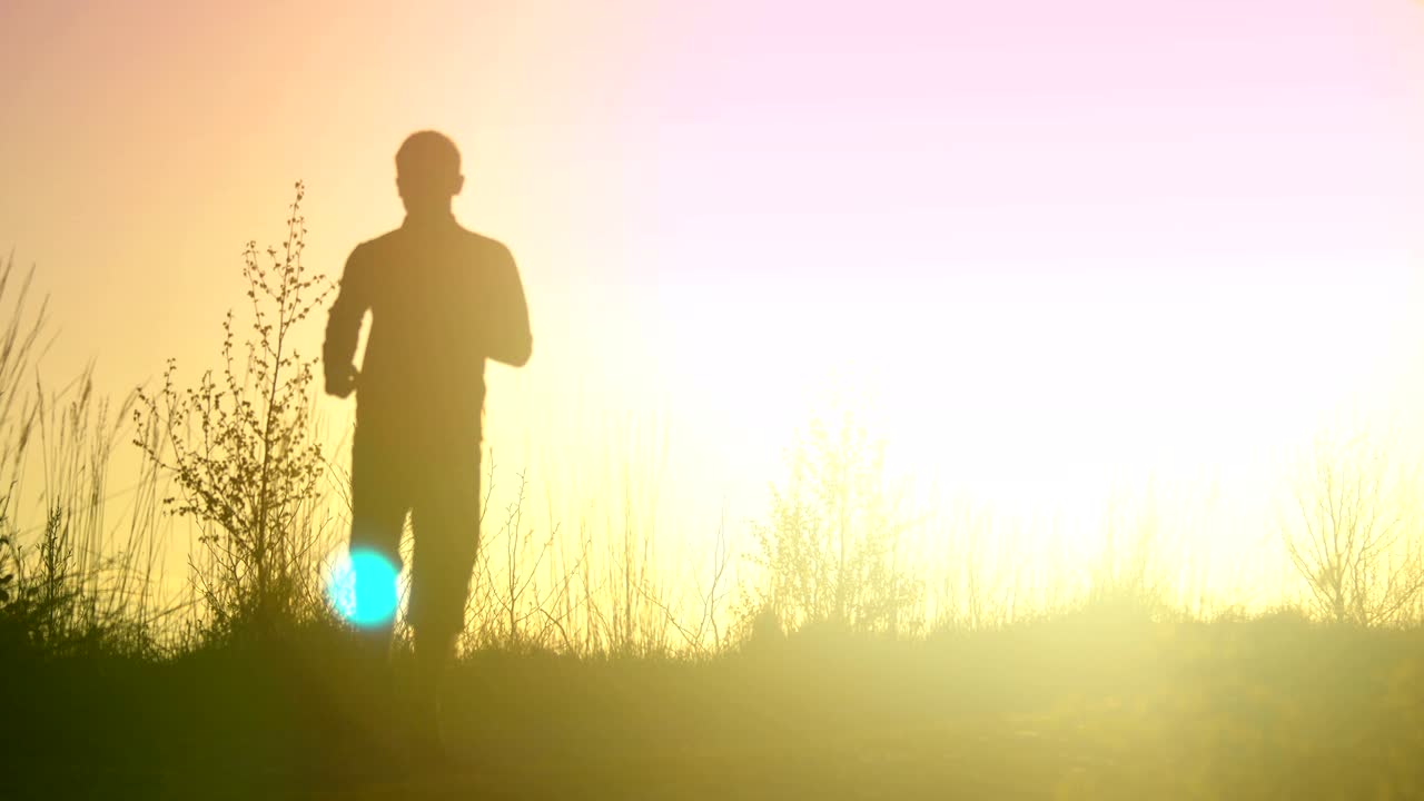 Young athletic man is running outdoor in the sunset in mountain landscape.