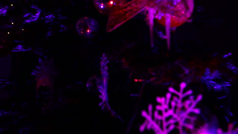 Christmas-tree-at-night-with-purple-lights---camera-moving-down