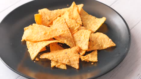 chips de tortilla de queso crujiente en un plato negro