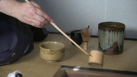 hot water is added to tea bowl and whisked during a japanese tea ceremony