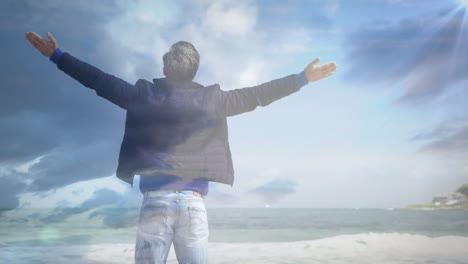 animación de luz brillante sobre el hombre con los brazos extendidos relajándose en la naturaleza contra el cielo azul