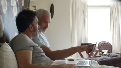 gay couple researching on laptop in hotel room shot on r3d