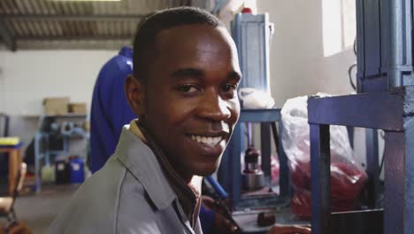 mixed race worker smiling in factory